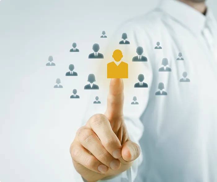 A person's index finger pointing towards a highlighted, golden-yellow stylized human icon, which is part of a larger network of smaller, dimmer human icons, symbolizing Customer Relationship Management (CRM)